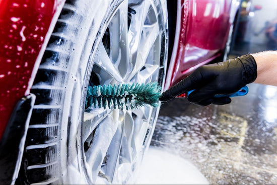 green scrubbing cleaning the soapy tires of a red care