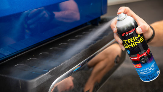 Person applying Trim Shine spray to a car's trim.